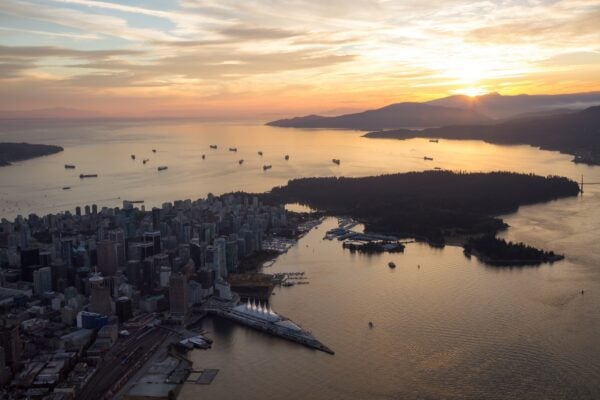 Aerial view of Downtown Vancouver City, BC, Canada. Taken from an airplane during a cloudy sunset. Modern Cityscape on West Coast Pacific Ocean