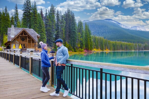 A couple of men and women standing by the lake looking at the mountains,Emerald Lake Yoho National Park Canada British Colombia. a beautiful lake in the Canadian Rockies during the autumn season.