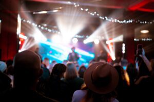 Photo of many people enjoying rock concert, crowd with raised up hands dancing in nightclub