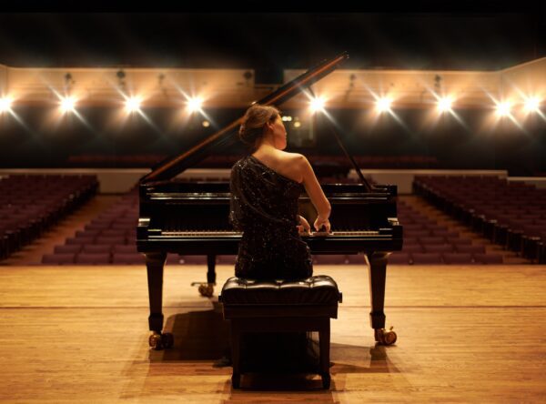 Showcasing her talent. Shot of a young woman playing the piano during a musical concert